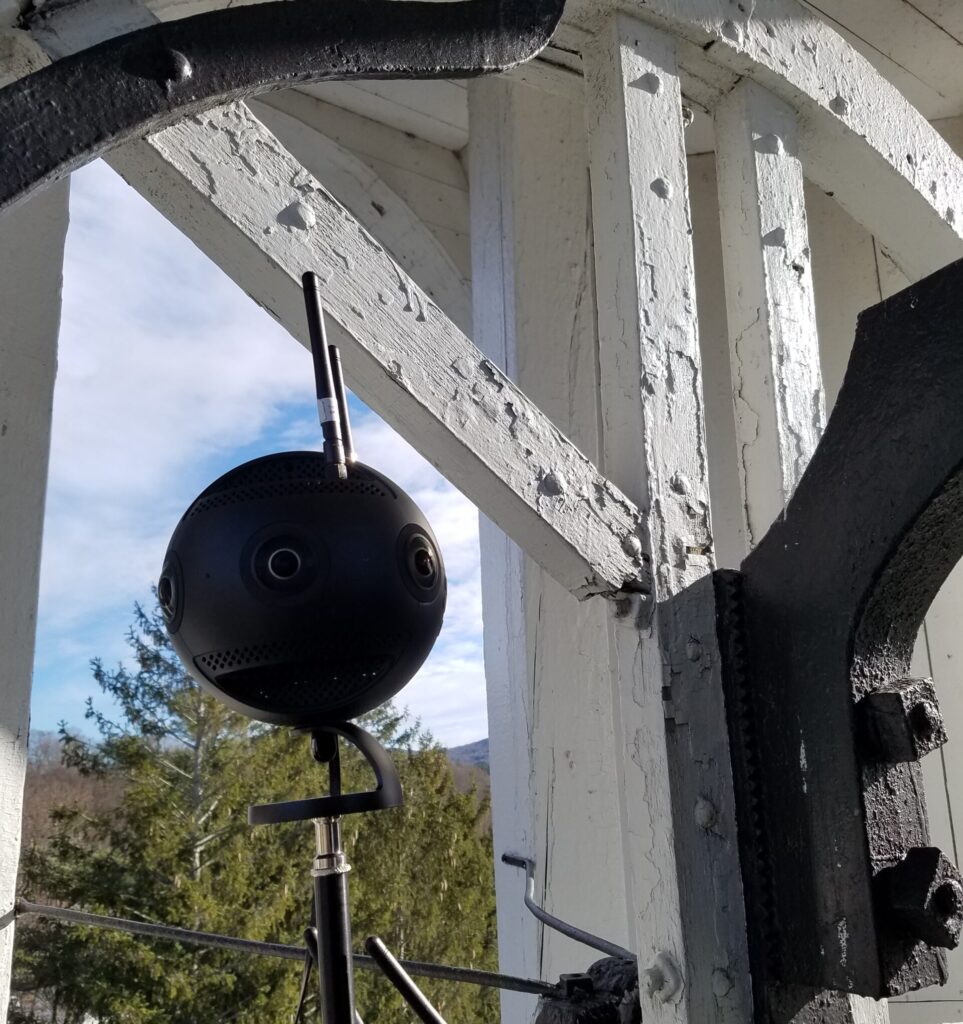 The Insta360 Pro 2 camera mounted on a light stand, shown on set in a Church bell tower.